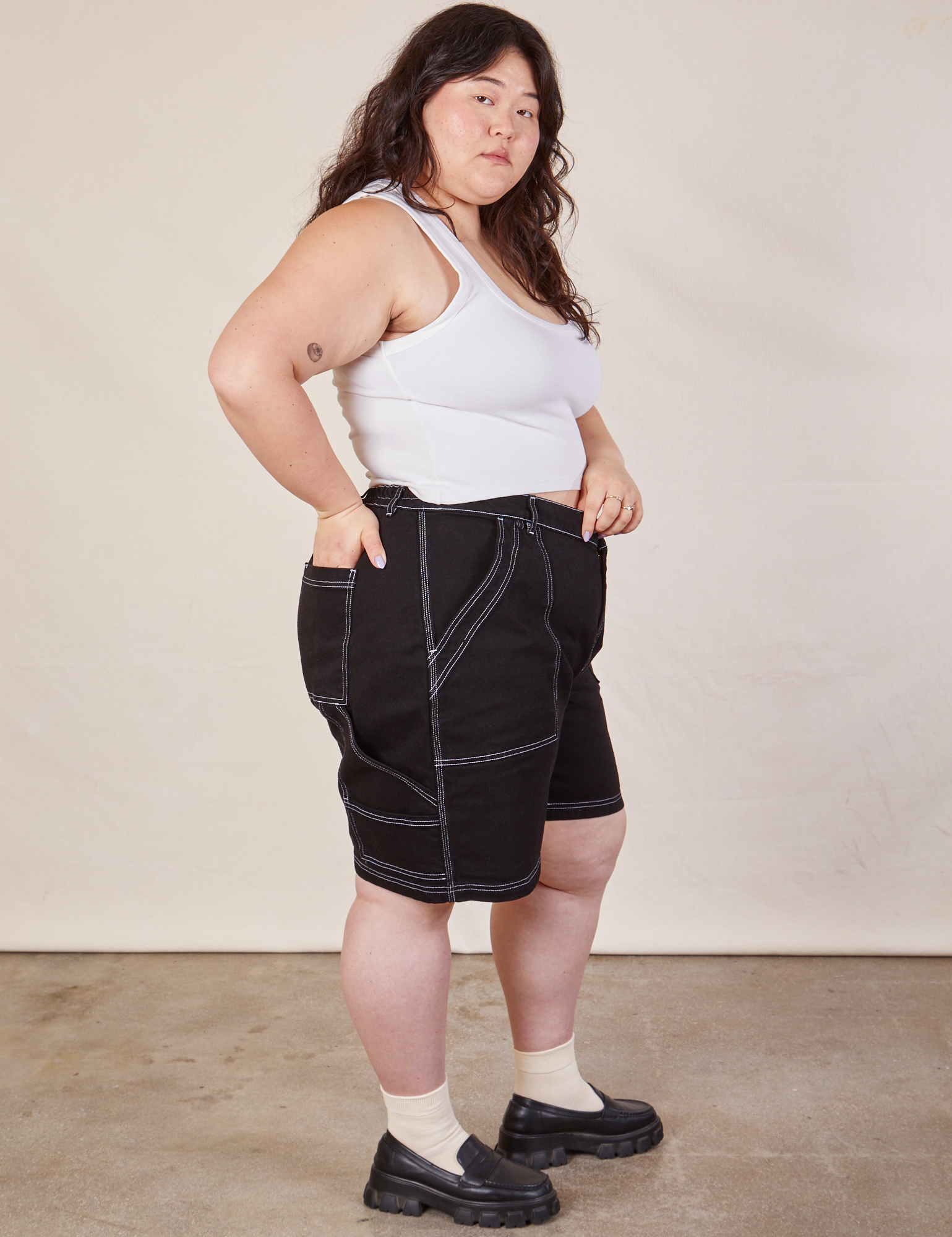 Side view of Carpenter Shorts in Basic Black and Cropped Tank in vintage tee off-white on Ashley