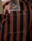 Close up of Jesse's hand in the back pocket of Longline Work Shorts in Fudgesicle Brown