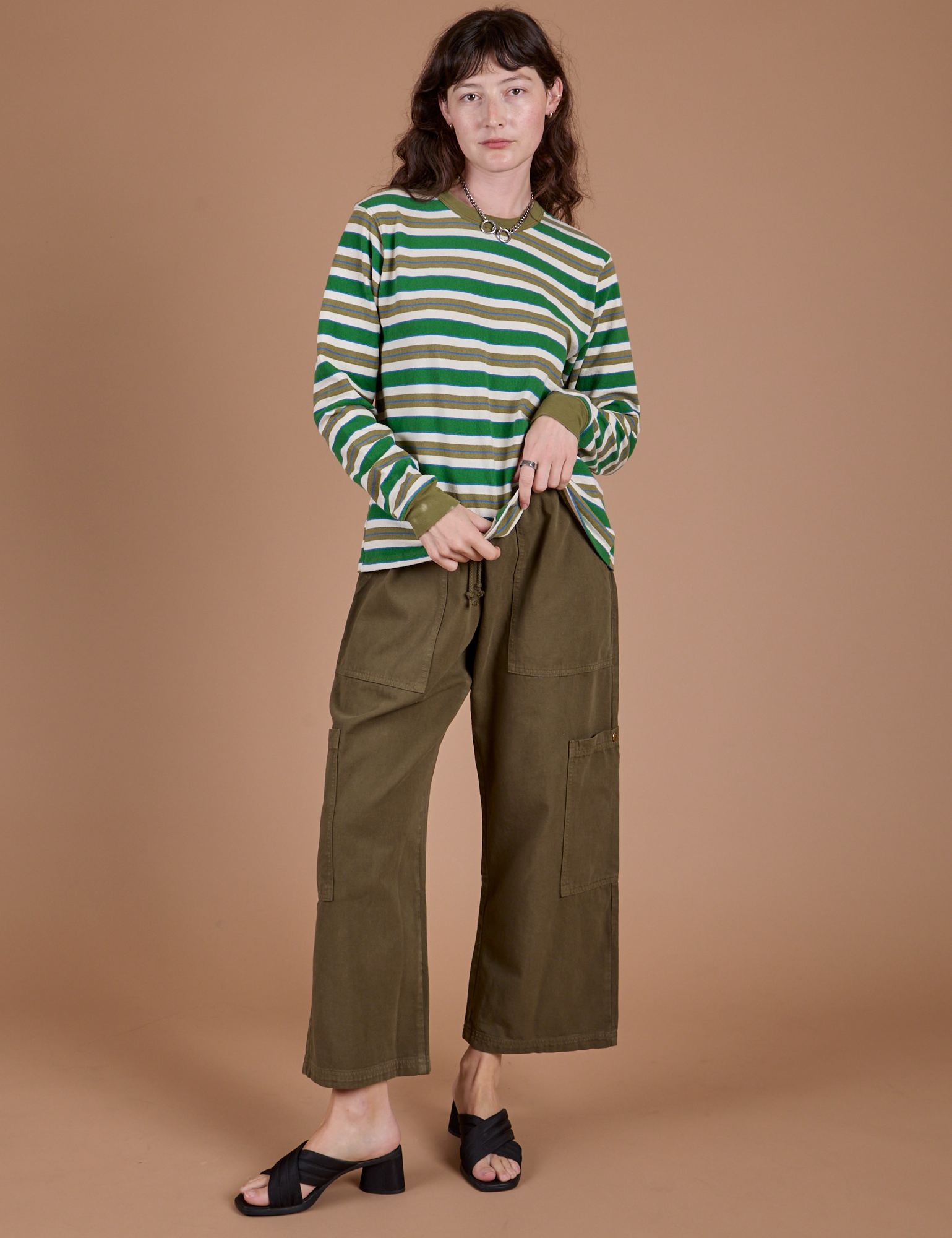 Alex is wearing Long Sleeve Striped Burly Tee in Green and Drop Pocket Cargo Pants in Surplus Green