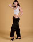 Angled front view of Baggy Mid-Rise Trousers in Basic Black and Cropped Tank in Vintage Tee White on Alex