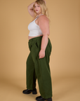 Side view of Baggy Mid-Rise Trousers in Evergreen and vintage tee white Cropped Tank on Juliet