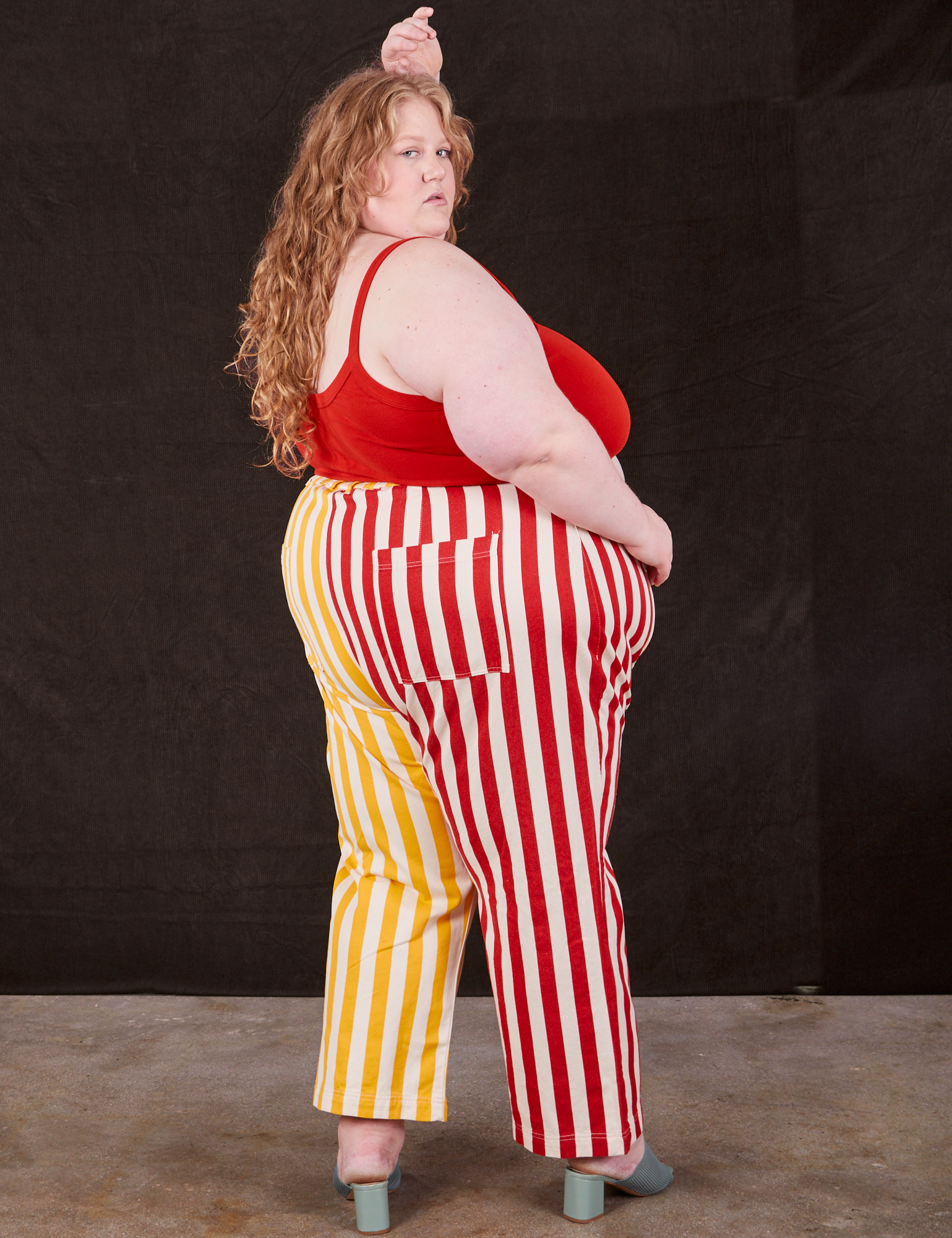 Angled back view of Western Pants in Ketchup/Mustard Stripes on Catie