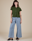Alex is wearing Pantry Button-Up in Evergreen and light wash Indigo Wide Leg Trousers