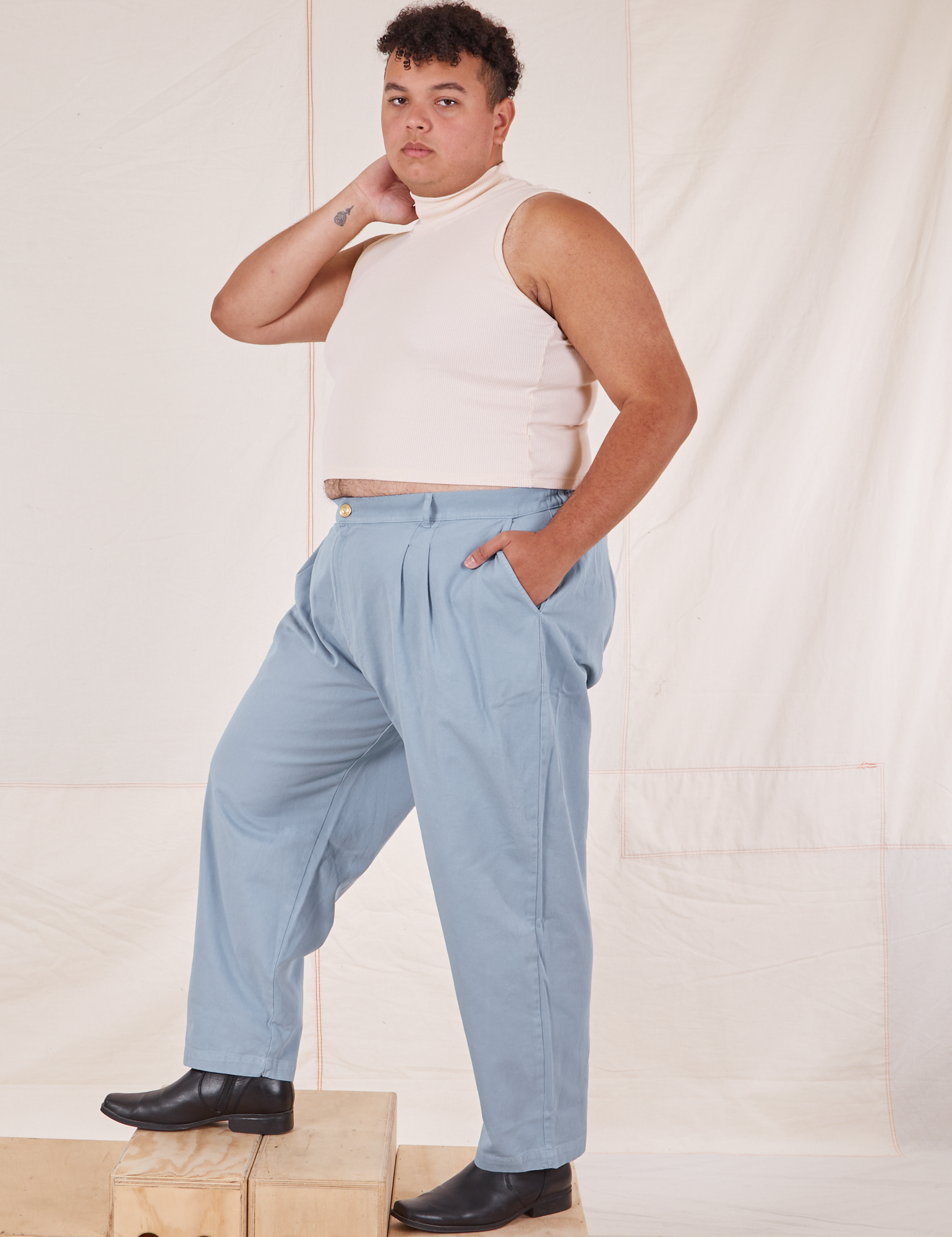Angled front view of Heavyweight Trousers in Periwinkle and Sleeveless Turtleneck in vintage tee off-white on Miguel