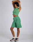 Angled front view of Longline Work Shorts in Seafoam Green and matching Muscle Tee on Kira