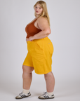 Side view of Longline Work Shorts in Sunshine Yellow and burnt terracotta Cropped Tank on Juliet