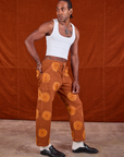 Side view of Paintstamped Work Pants in Orange and Cropped Tank in vintage tee off-white on Jerrod