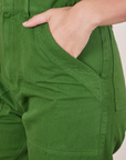 Front pocket close up of Short Sleeve Jumpsuit in Lawn Green. Alex has her hand in the pocket.