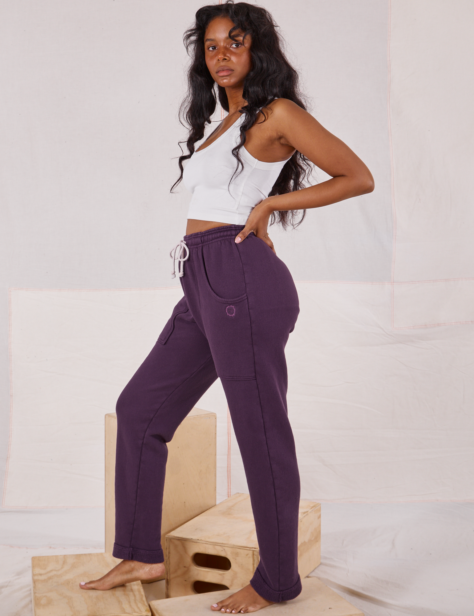 Side view of Rolled Cuff Sweat Pants in Nebula Purple and vintage off-white Cropped Tank on Kandia