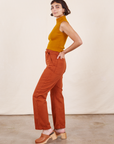 Work Pants in Burnt Terracotta side view on Soraya wearing spicy mustard Sleeveless Turtleneck