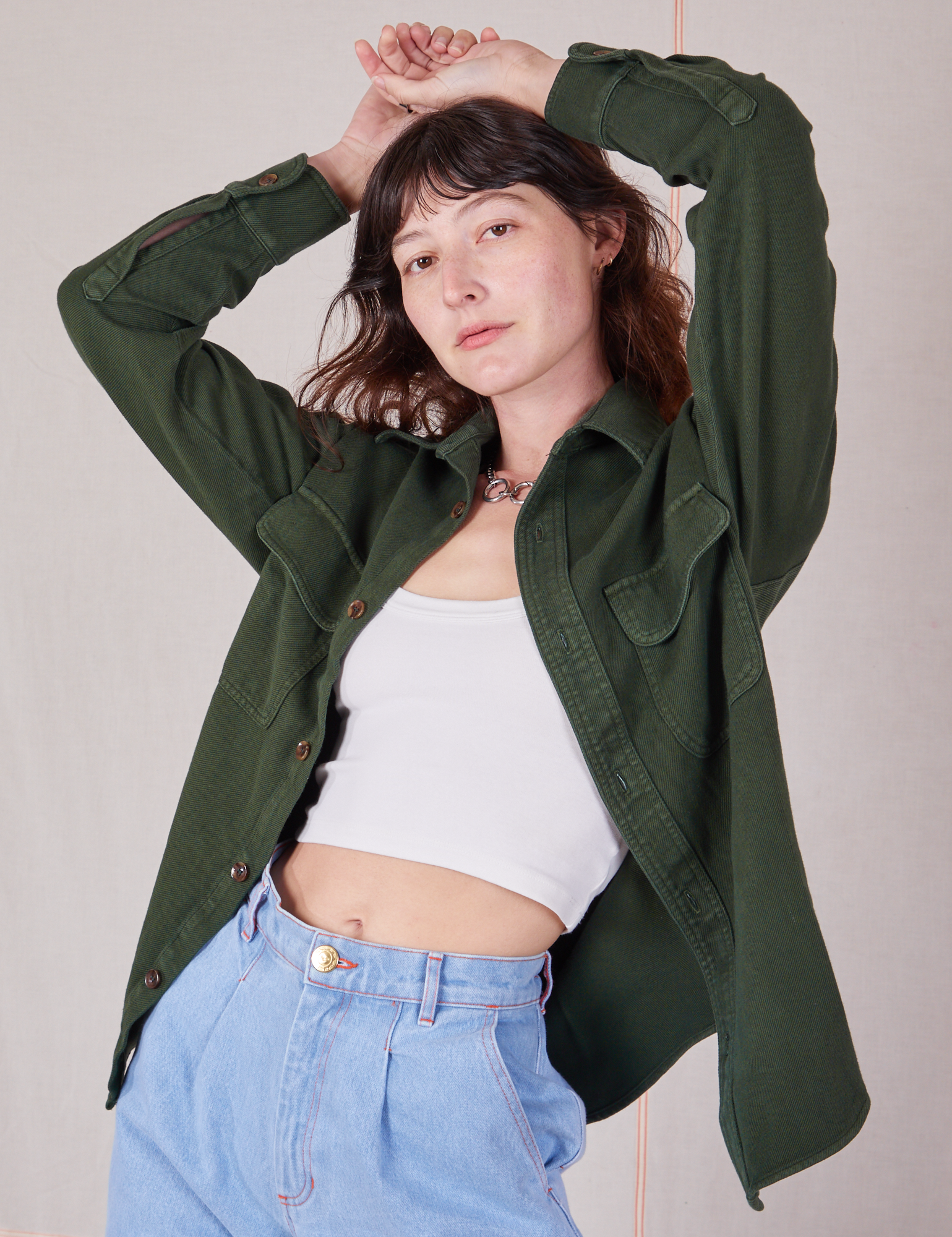Alex is wearing Flannel Overshirt in Swamp Green, vintage off-white Cropped Cami and light wash Trouser Jeans