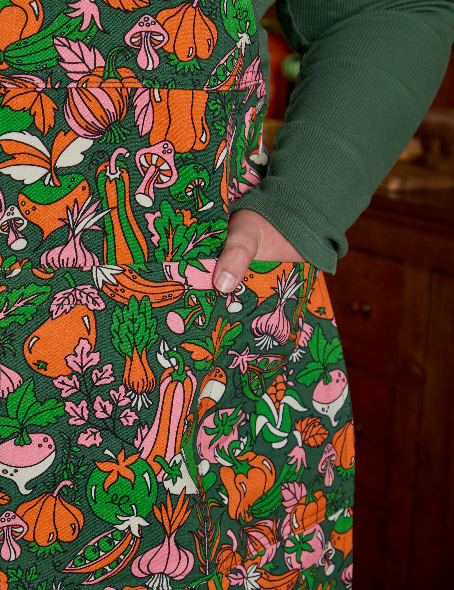 Juliet's hand is in the front pocket of Kitchen Collection Full Apron