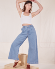 Alex is wearing Indigo Wide Leg Trousers in Light Wash and vintage off-white Cropped Tank Top