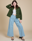Alex is wearing Denim Work Jacket in Evergreen and light wash Indigo Wide Leg Trousers