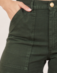 Classic Work Shorts in Swamp Green front pocket close up. Tiara has her hand in the pocket.