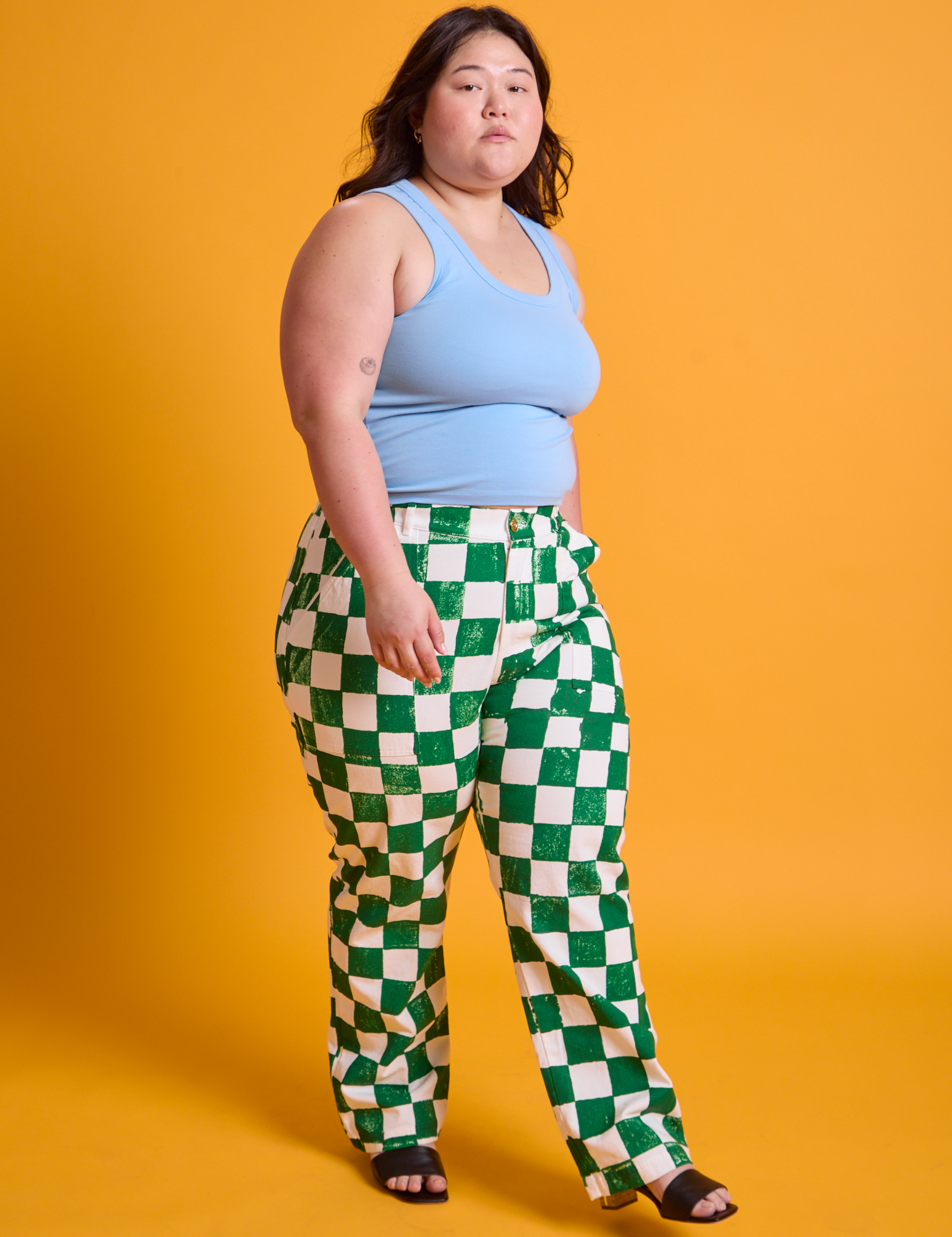Angled front view of Checkerboard Work Pants in White/Green and baby blue Tank Top on Ashley