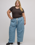 Juliet is wearing Baby Tee in Espresso Brown tucked into light wash denim drop pocket pants