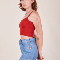 Side view of Cropped Cami in Mustang Red and light wash Frontier Jeans worn by Alex