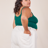 Angled back view of Cropped Cami in Hunter Green and vintage off-white Western Pants worn by Alicia.