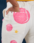 Close up of Kandia's hand in the back pocket of Paintstamped Work Pants in Bubblegum
