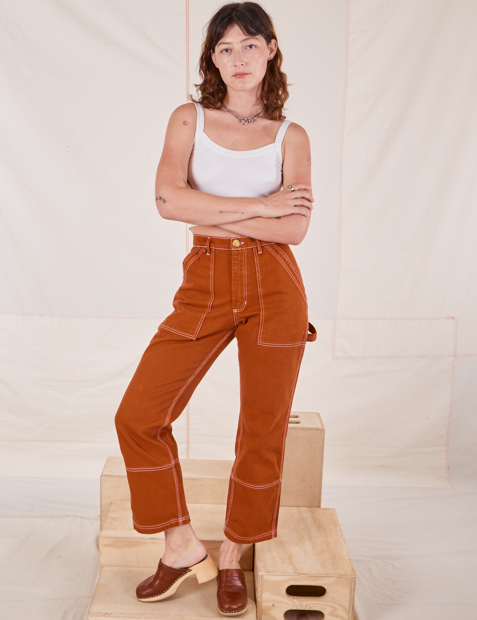 Alex is wearing Carpenter Jeans in Burnt Terracotta and Cropped Cami in vintage tee off-white