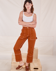 Alex is wearing Carpenter Jeans in Burnt Terracotta and vintage off-white Cropped Cami