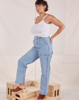 Angled front view of Carpenter Jeans in Light Wash and Cropped Cami in vintage tee off-white worn by Tiara