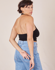 Back view of Halter Top in Basic Black and light wash Frontier Jeans worn by Tiara