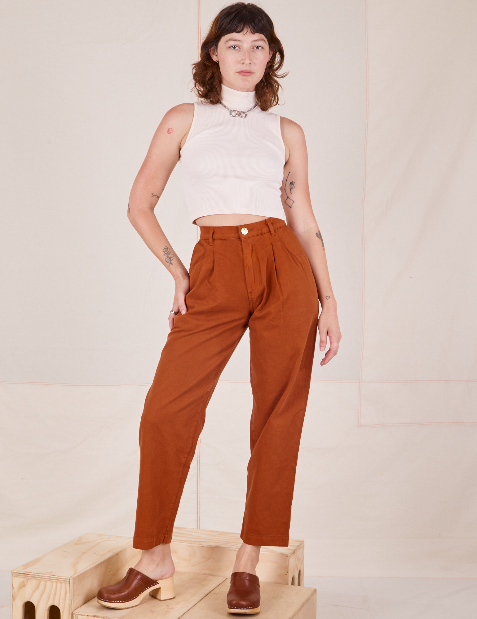 Alex is 5&#39;8&quot; and wearing XXS Heavyweight Trousers in Burnt Terracotta paired with Sleeveless Turtleneck in vintage tee off-white