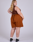 Angled back view of Pleated Trouser Shorts in Burnt Terracotta and fudgesicle brown Mini Tank on Juliet