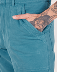 Pocket close up of Heritage Short Sleeve Jumpsuit in Marine Blue. Jesse has their hand in the pocket.