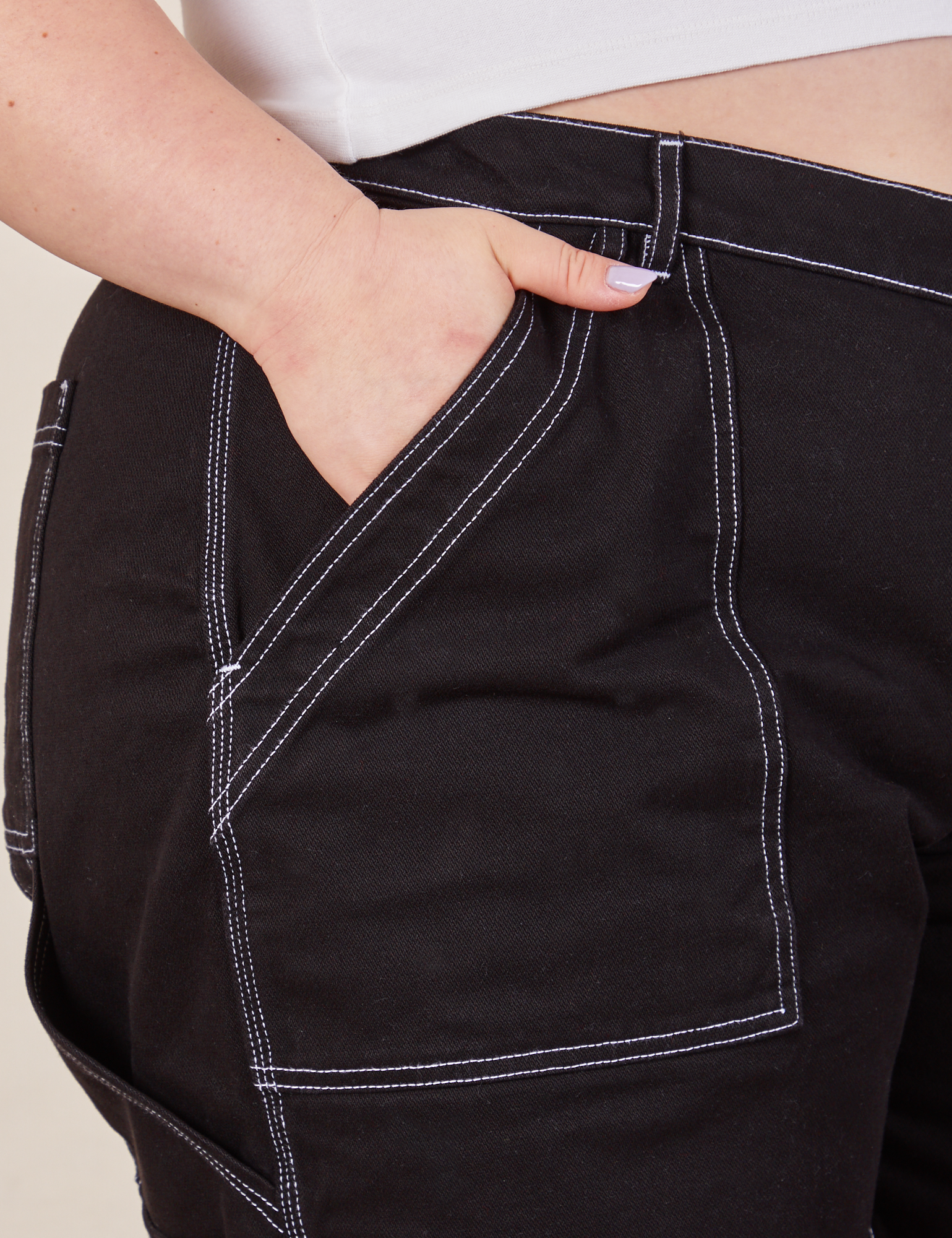 Carpenter Shorts in Basic Black front pocket close up. Ashley has her hand in the pocket.