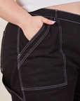 Carpenter Shorts in Basic Black front pocket close up. Ashley has her hand in the pocket.