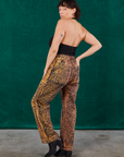 Angled back view of Leopard Work Pants and black Halter Top on Tiara