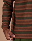 Long Sleeve Striped Burly Tee in Fudgesicle bottom close up with Jerrod holding the hem