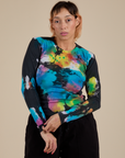Tiara is wearing Long Sleeve Baby Tee in Rainbow Magic Waters