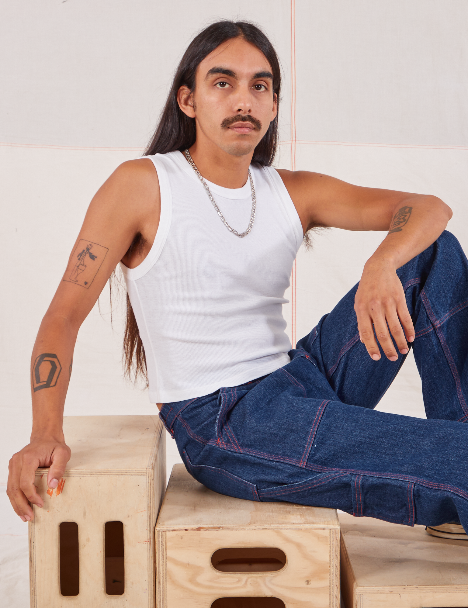 Anthony is wearing Muscle Tee in Vintage Tee Off-White and dark wash Carpenter Jeans