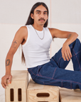 Anthony is wearing Muscle Tee in Vintage Tee Off-White and dark wash Carpenter Jeans