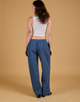 Back view of Baggy Mid-Rise Trousers in French Blue and vintage tee white Cropped Tank on Alex