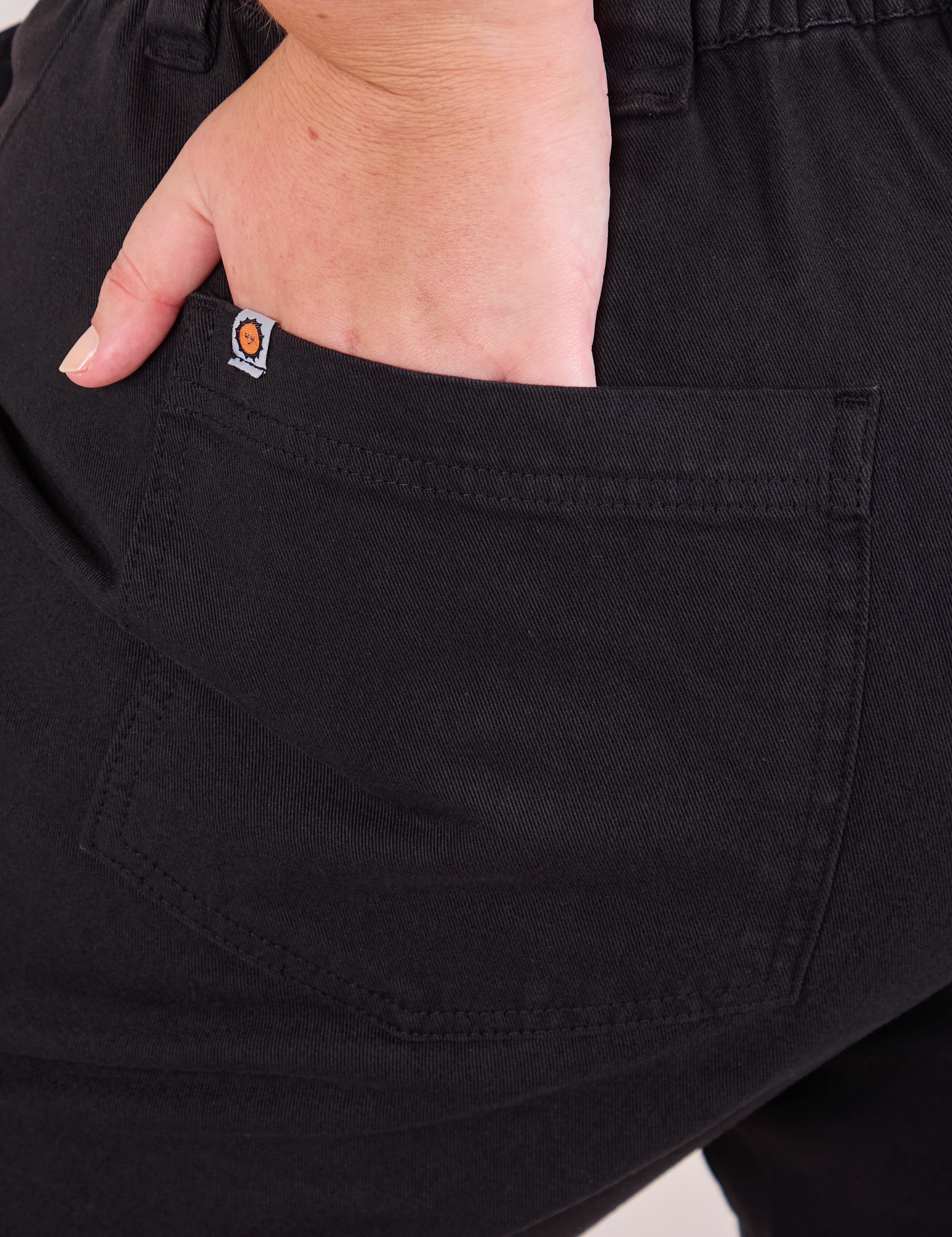 Mid-Rise Work Pants in Basic Black close up of Juliet's hand in the back pocket