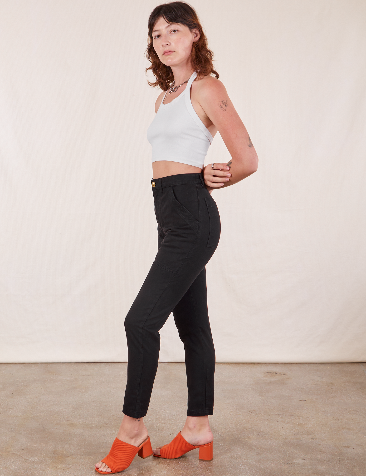 Side view of Pencil Pants in Basic Black and Halter Top in vintage tee off-white worn by Alex
