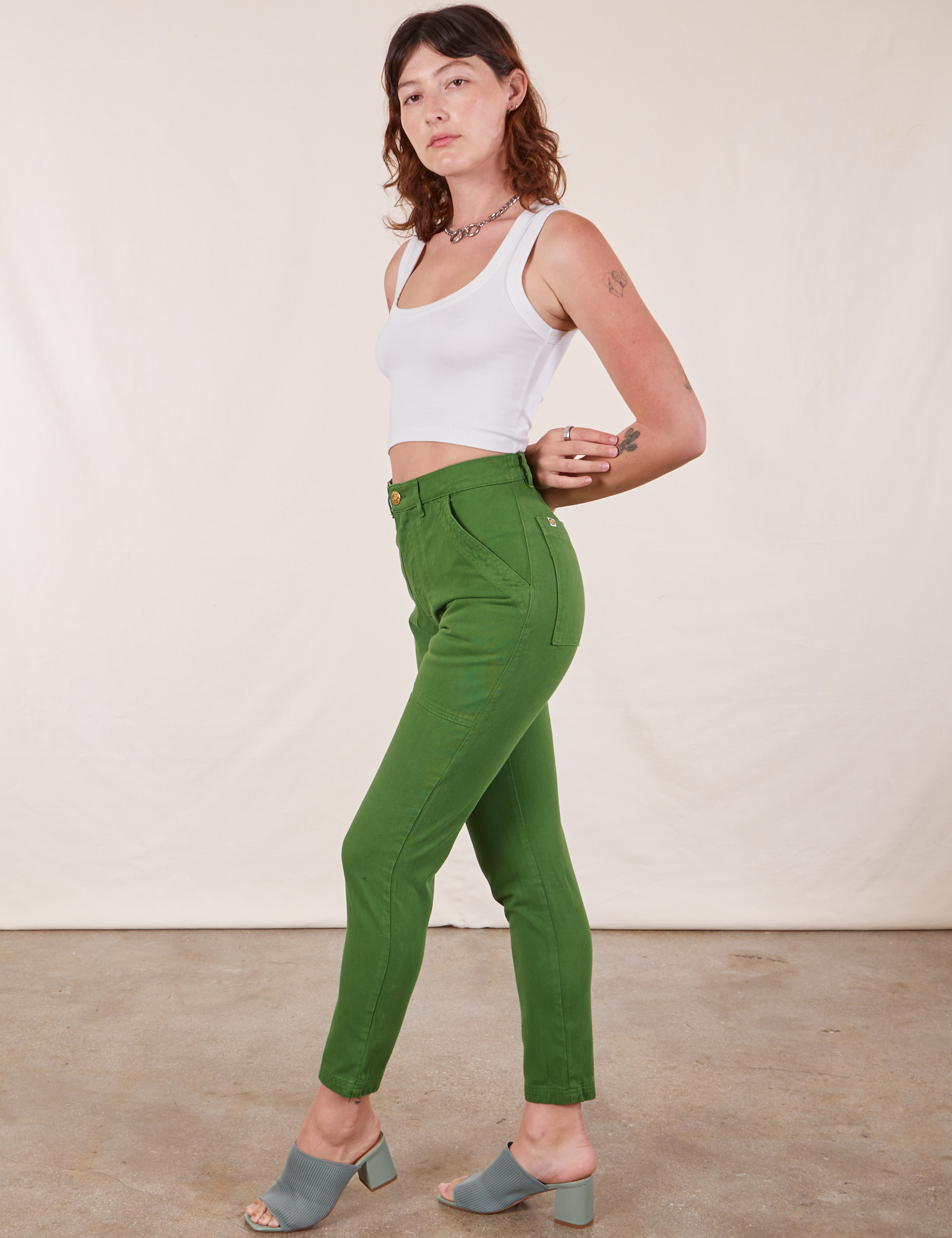 Side view of Pencil Pants in Lawn Green and Cropped Tank Top in vintage tee off-white
