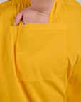 Close up of Juliet's hand in the back pocket of Drop Pocket Cargo Pants in Sunshine Yellow