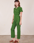 Angled side view of Short Sleeve Jumpsuit in Lawn Green worn by Alex