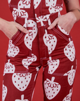 Close up of Alex's hands in the front pockets of Strawbaby Jumpsuit