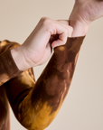 Close up of Long Sleeve Baby Tee in Honey Brown sleeves on Alex