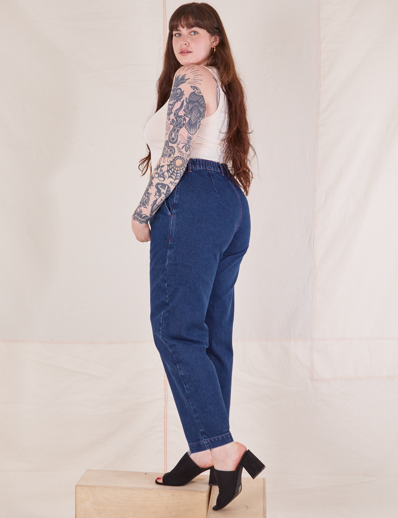 Side view of Denim Trouser Jeans in Dark Wash and Tank Top in vintage tee off-white worn by Sydney