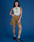 Alex is wearing Produce Raglan Tee in Onion tucked into shorts