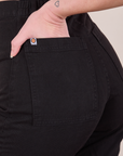 Close up of Alex's hand in the back pocket of Western Pants in Basic Black