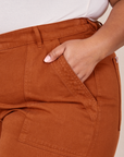 Classic Work Shorts in Burnt Terracotta front pocket close up. Morgan has her hand in the pocket.